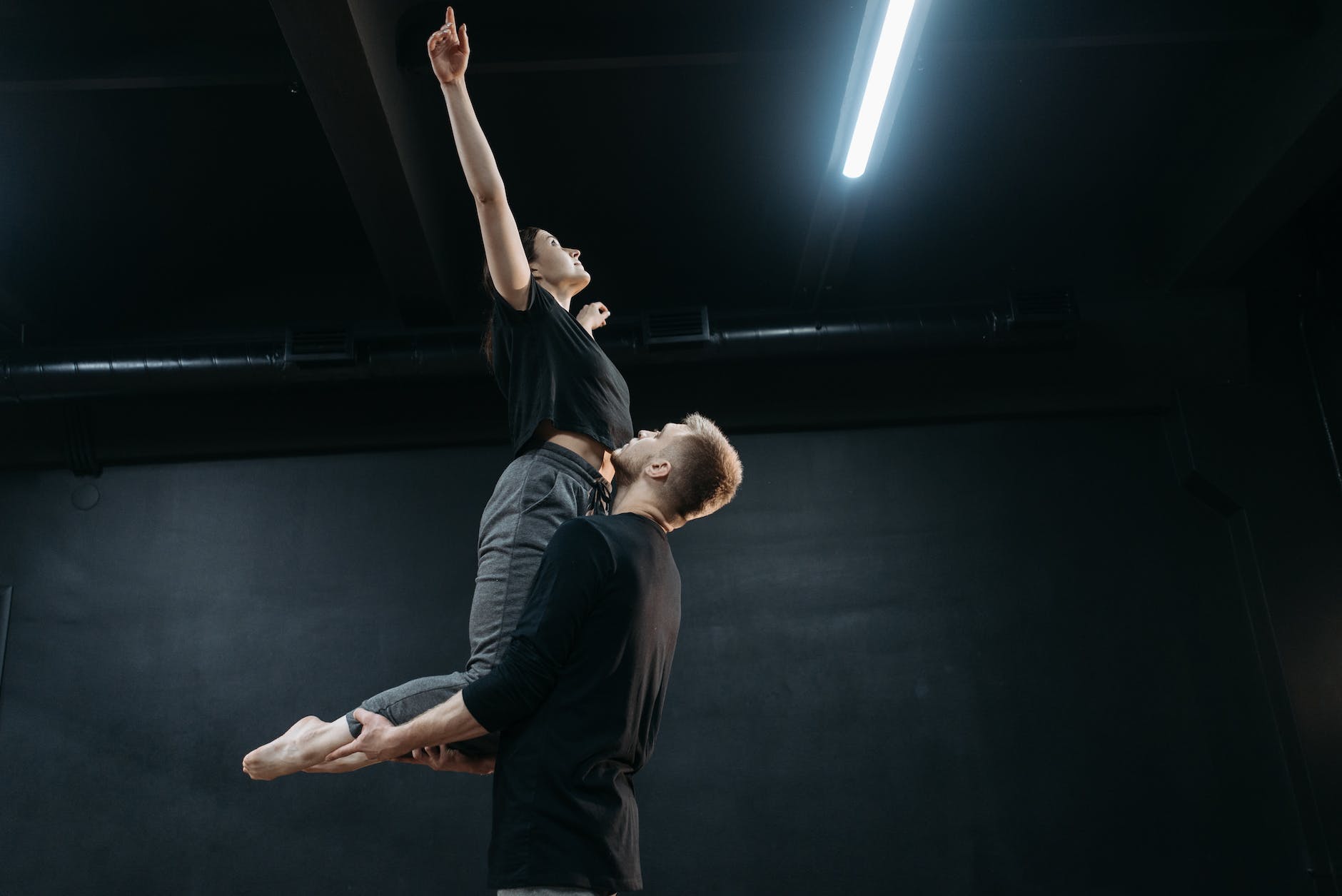a man in black shirt lifting a woman