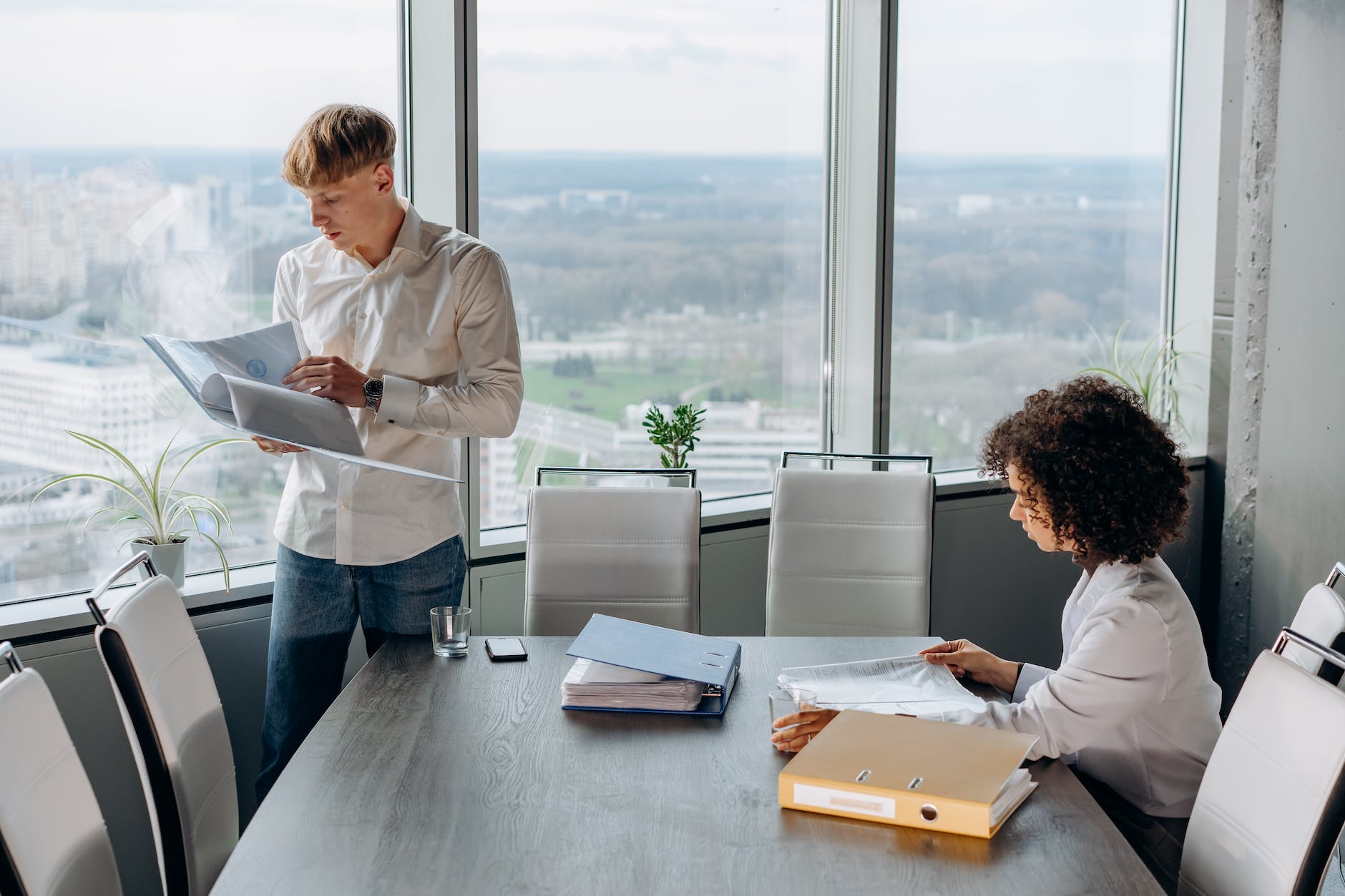 employees in white long sleeve shirt busy working inside an office